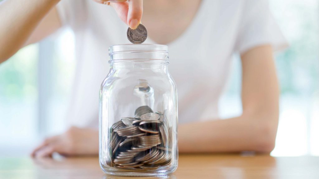 Woman Dropping Coins in Jar