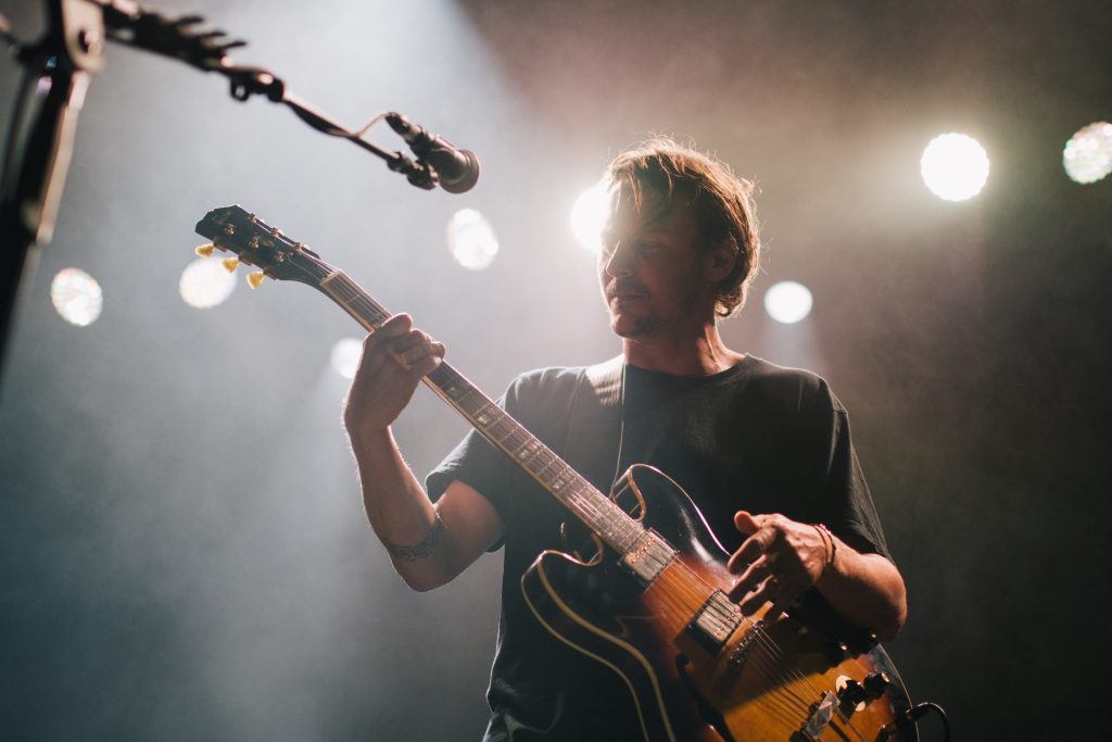 A man is setting tune of guitar