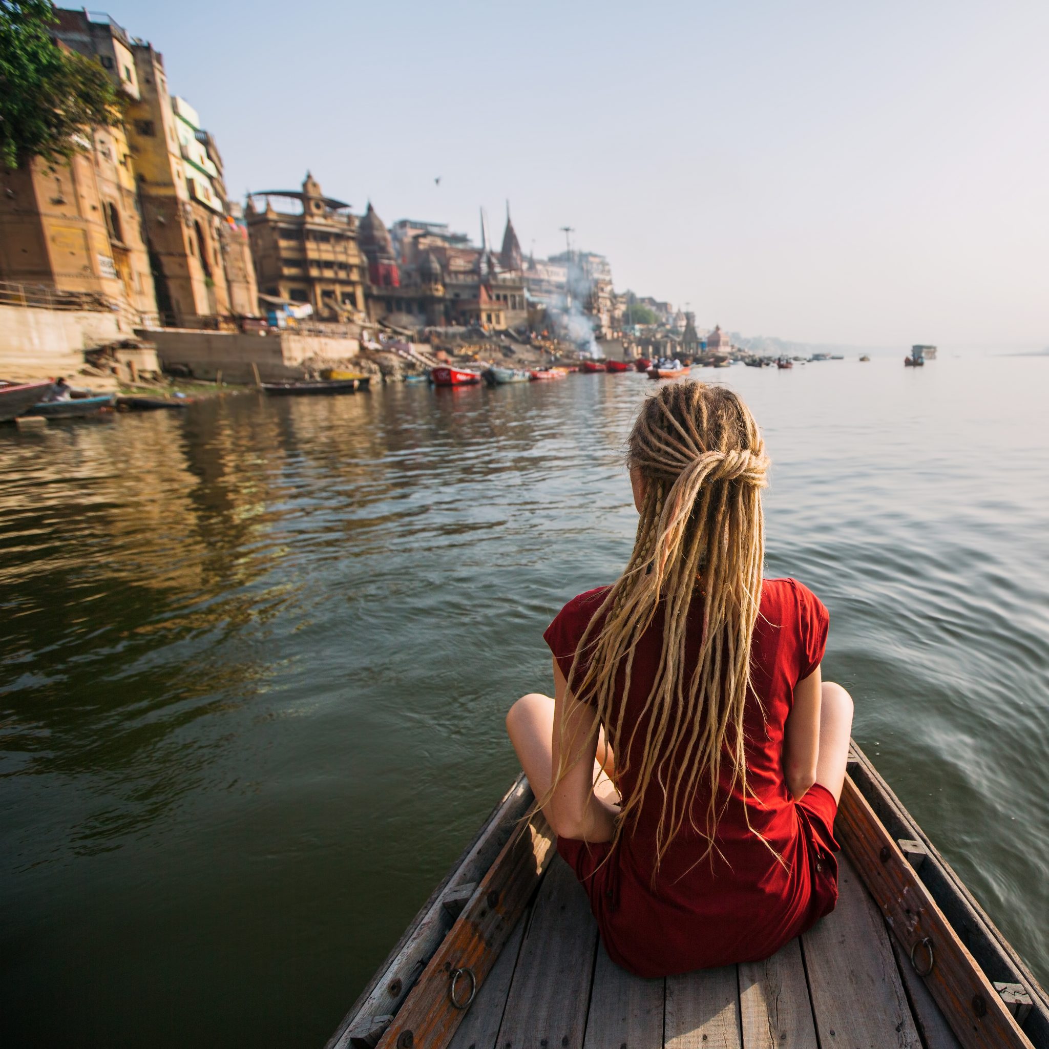 Woman traveler on a boat in the Ganges river waters, Varanasi, India.