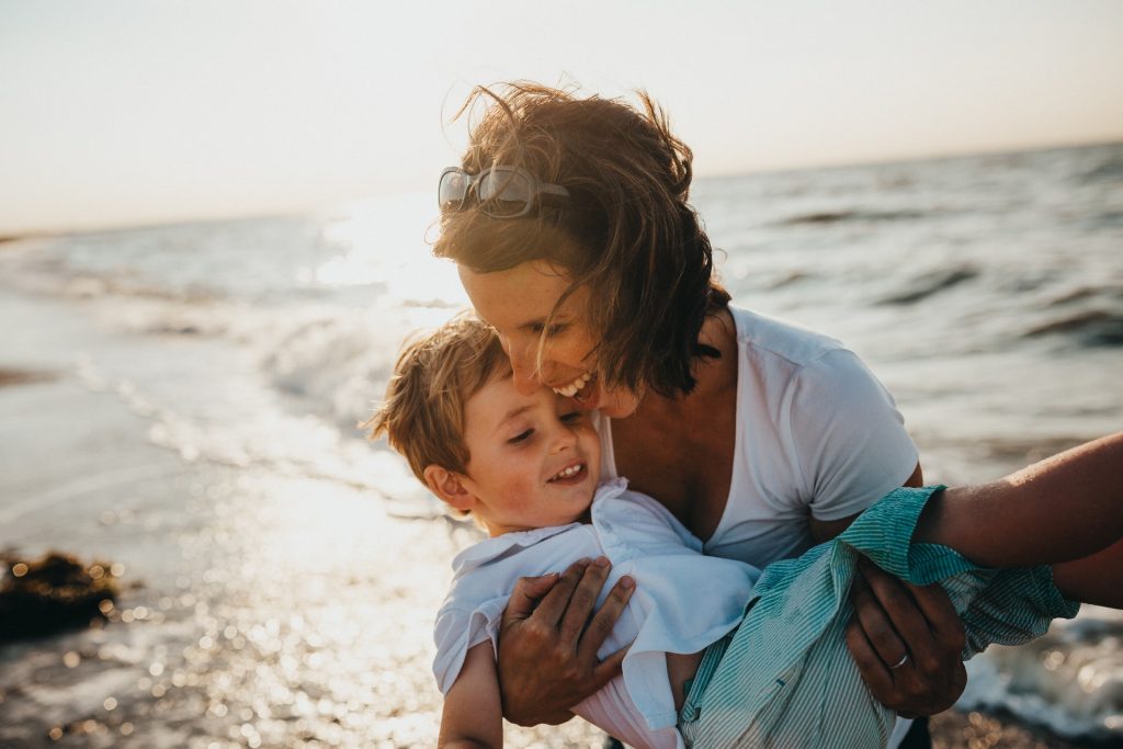 mother and child beside body of water