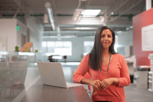 Woman standing next to a laptop