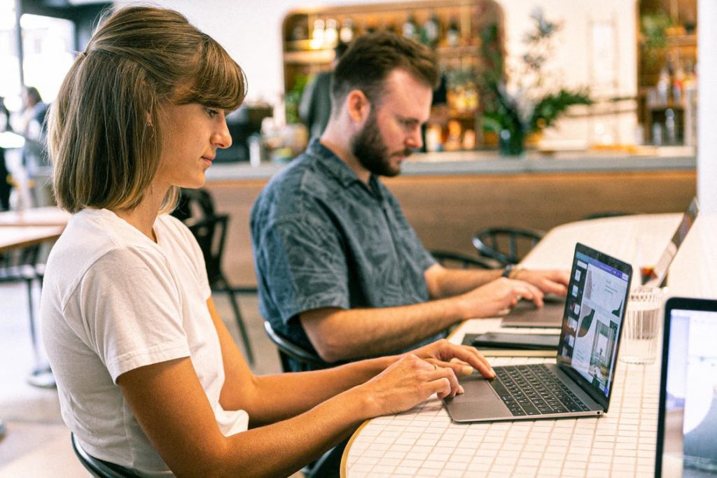 Two colleagues working on their laptops